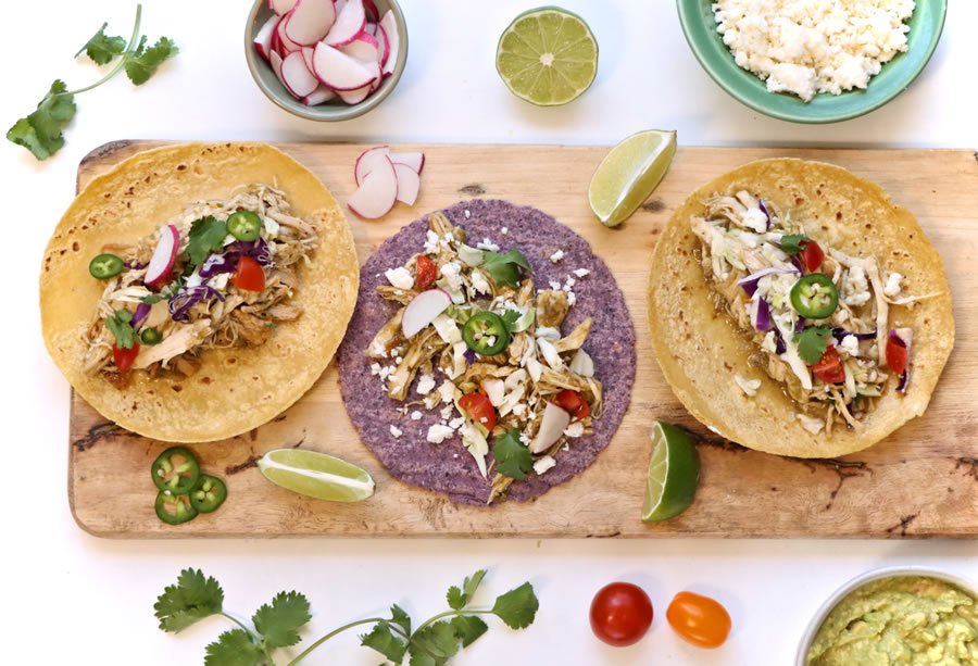 3 tacos au poulet au chili vert dans des tortillas de maïs sur un plateau de service