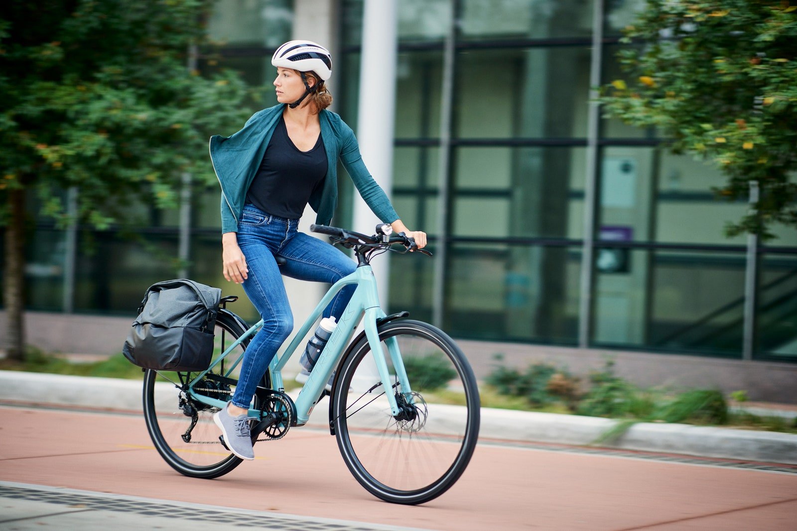 Personne conduisant le vélo électrique Trek FX 2 dans une rue de la ville.