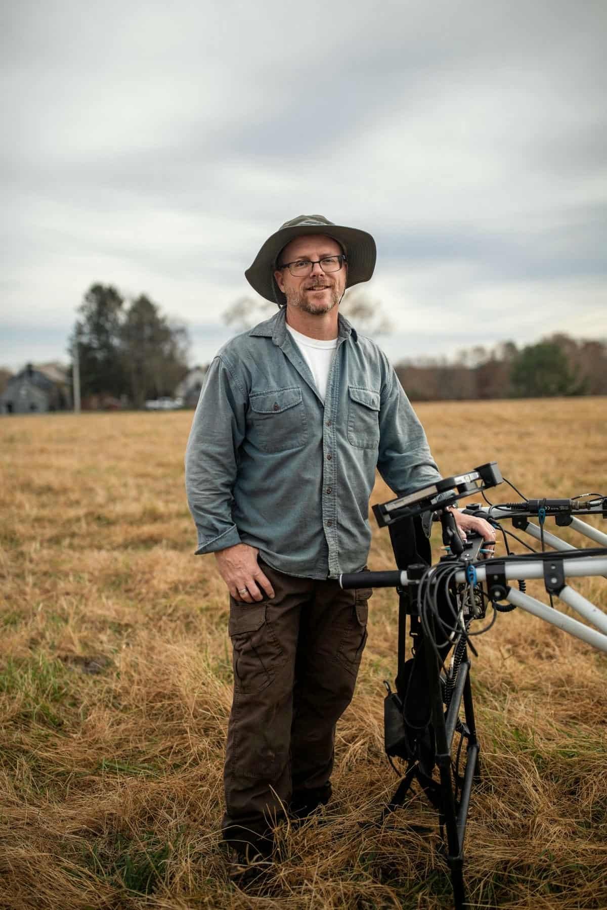 portrait de Jarrod Burks sur le terrain avec un équipement magnétométrique