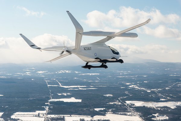 un petit avion blanc avec une hélice sur le dos survole un paysage