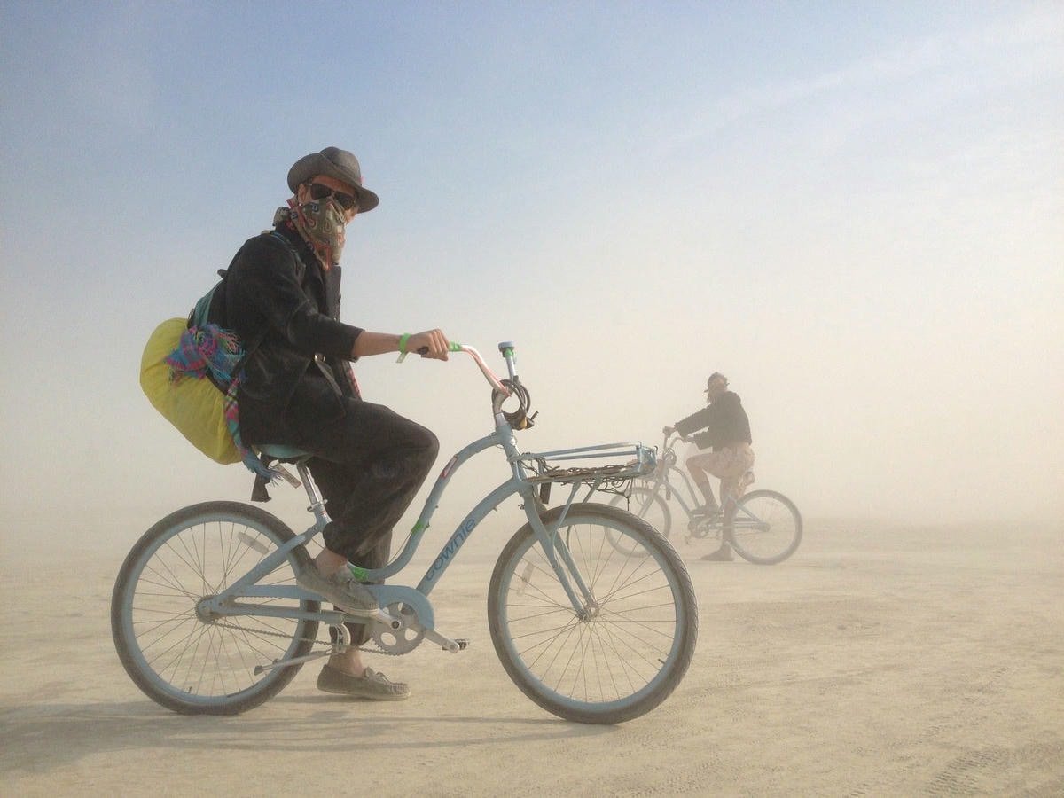 Deux personnes à bicyclette au milieu d'un paysage désertique poussiéreux