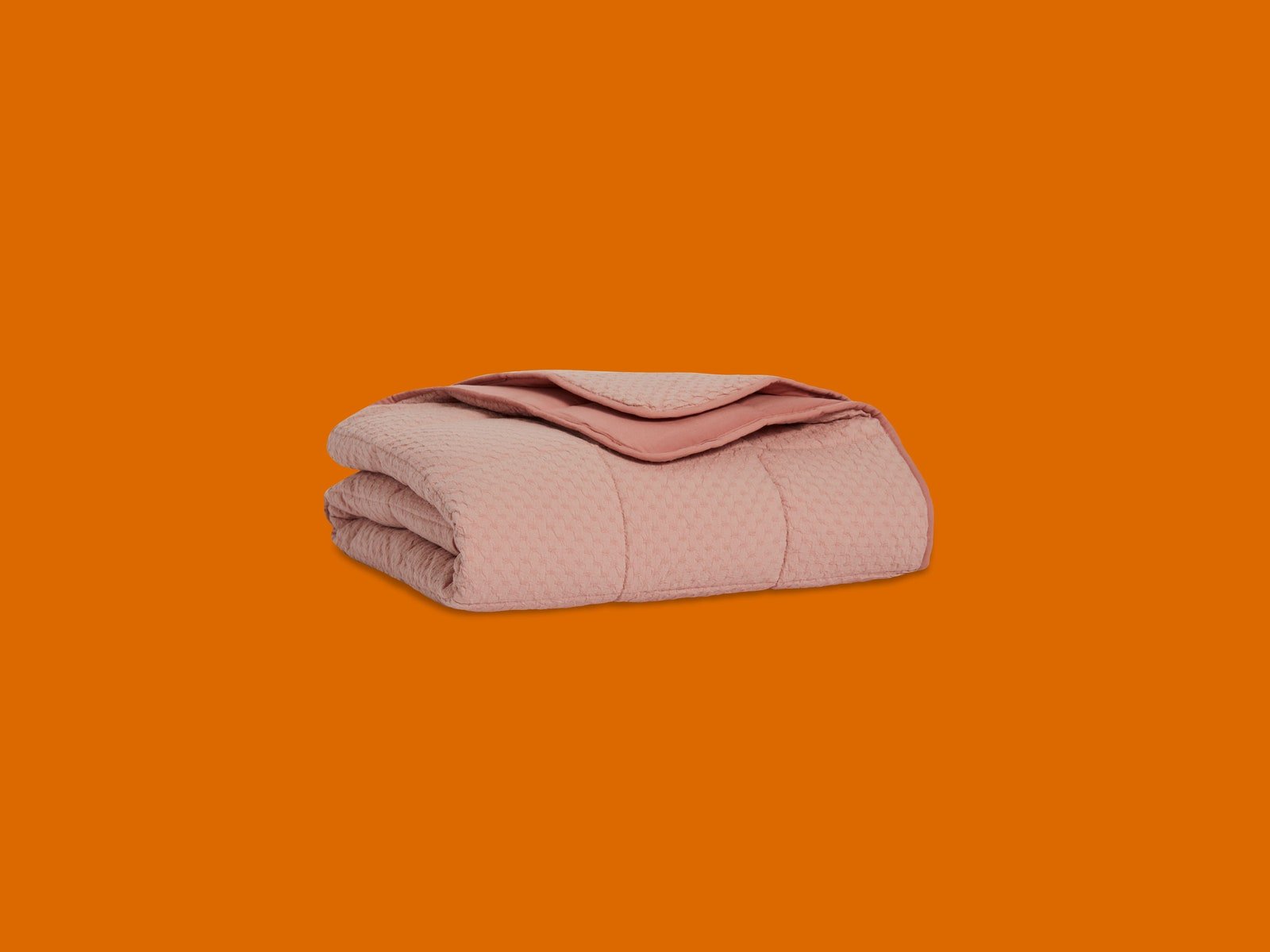 Couverture Brooklinen rose sur fond orange