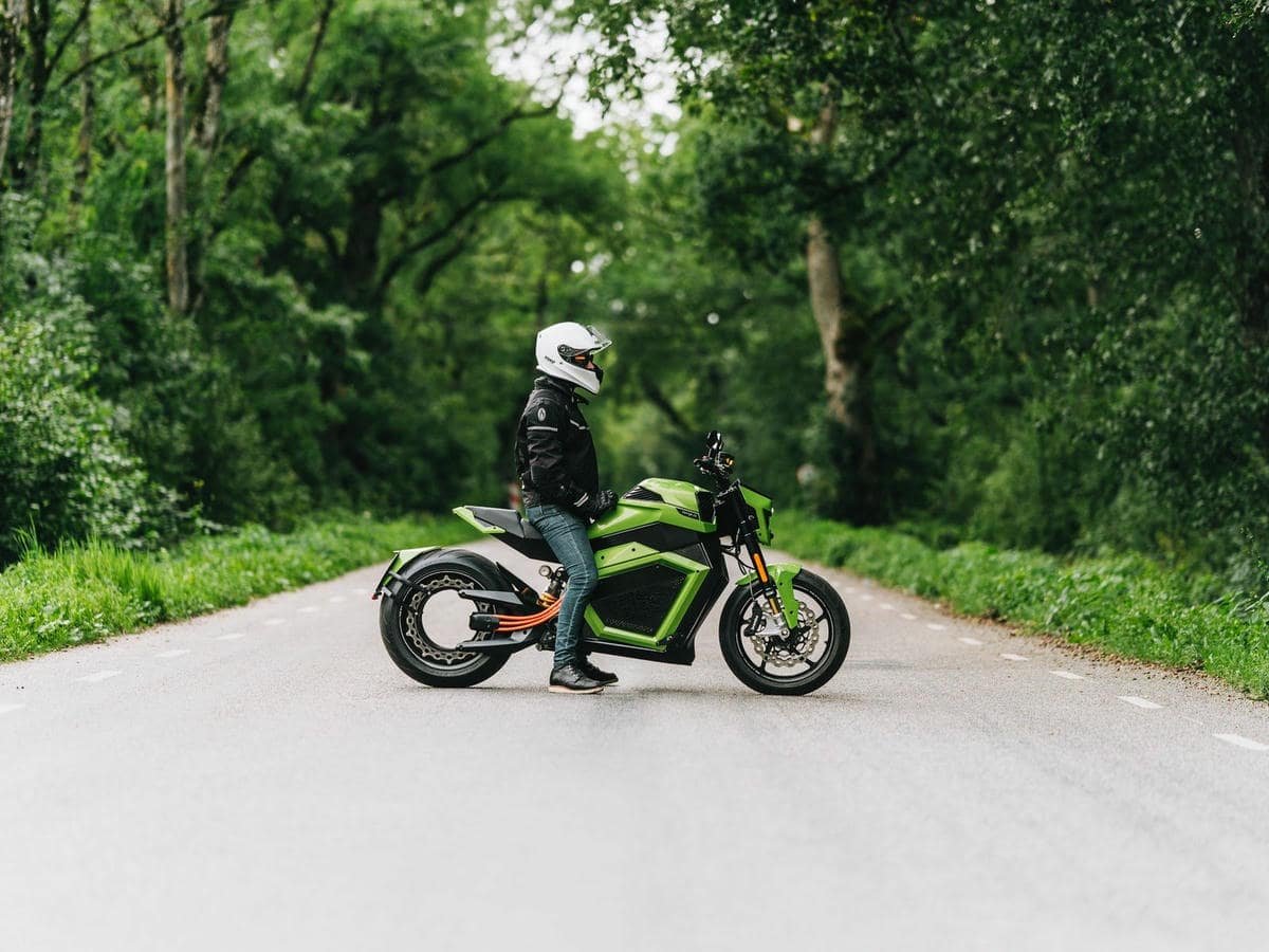 Personne assise sur la moto électrique Verge TS Pro sur une chaussée vide