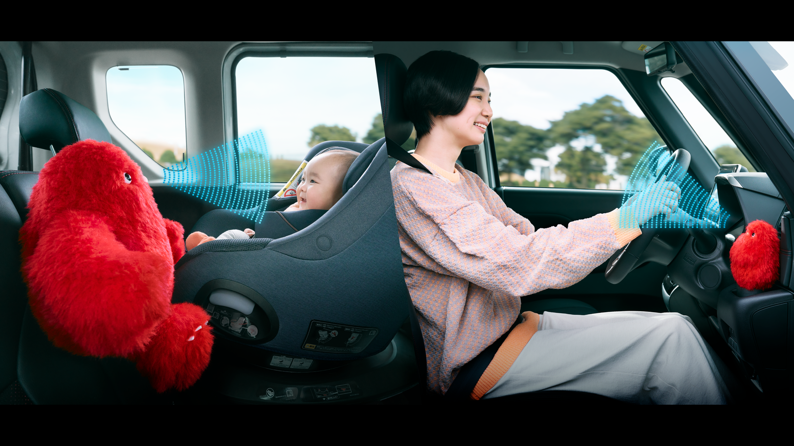 Bébé gauche dans un siège auto regardant un jouet à fourrure.  Droite.  Parent conduisant devant.